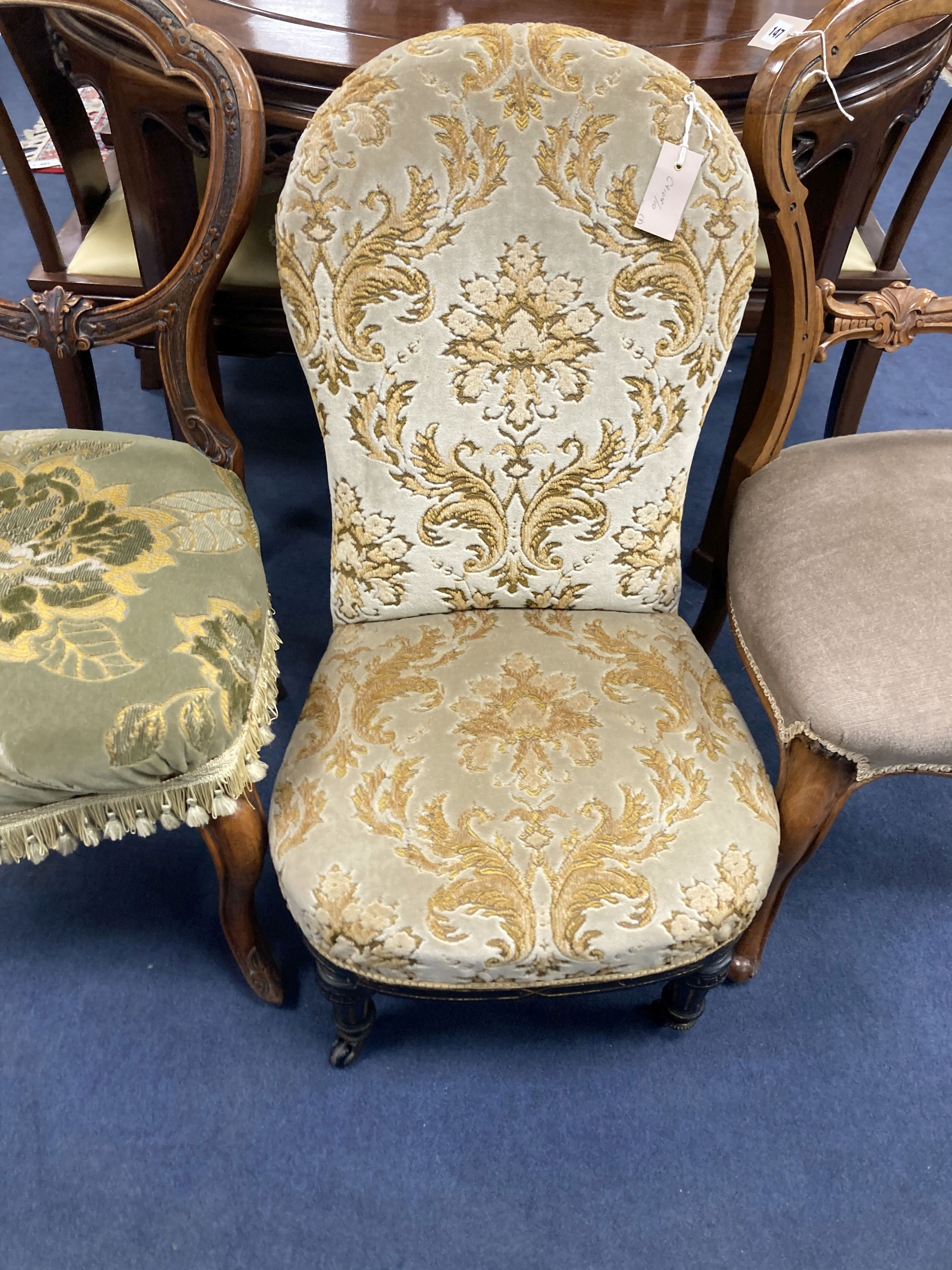 A Victorian ebonised and gilt upholstered nursing chair and pair of balloon back chairs